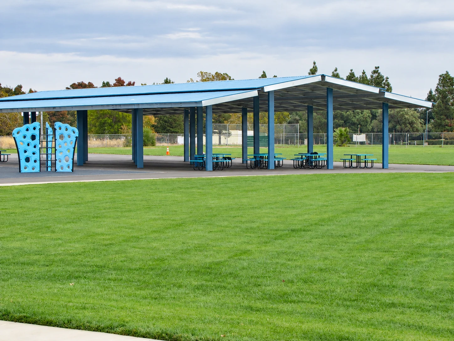 Double-gable roof and steel columns shading outdoor tables at Laurel Creek Elementary