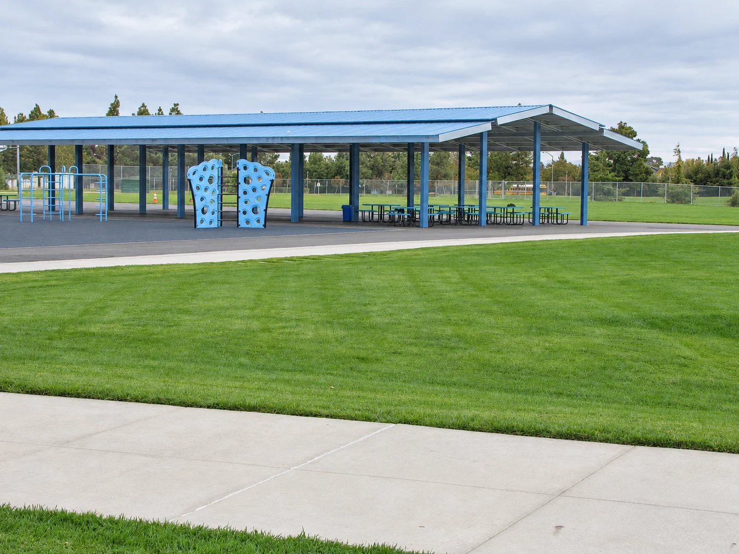 Wide view of the Laurel Creek Elementary canopy beside blue playground equipment