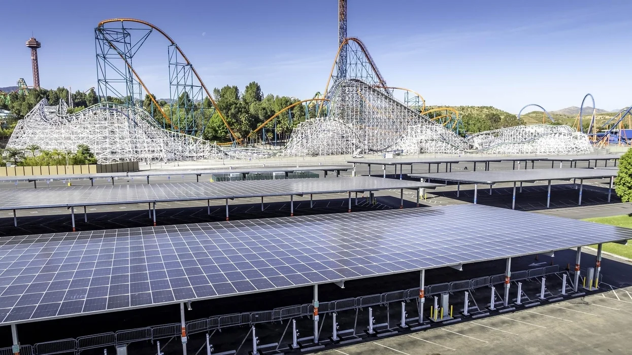 Solar carport structures and covered parking with Magic Mountain roller coasters in the background